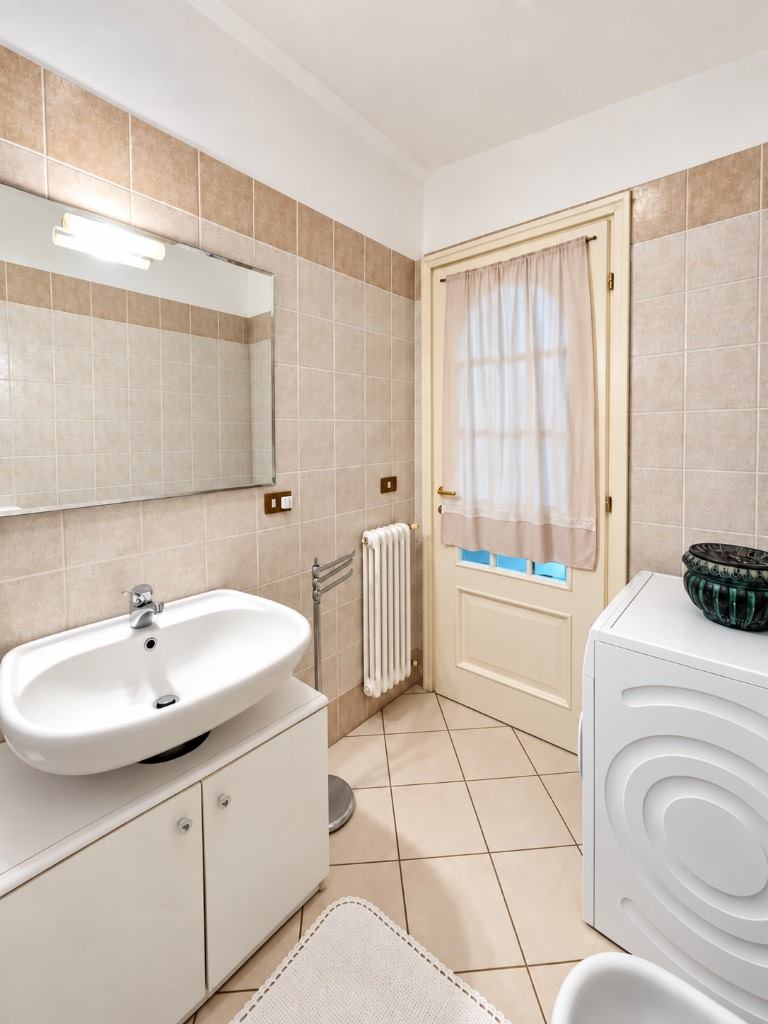 Bagno padronale, lavabo e lavatrice.